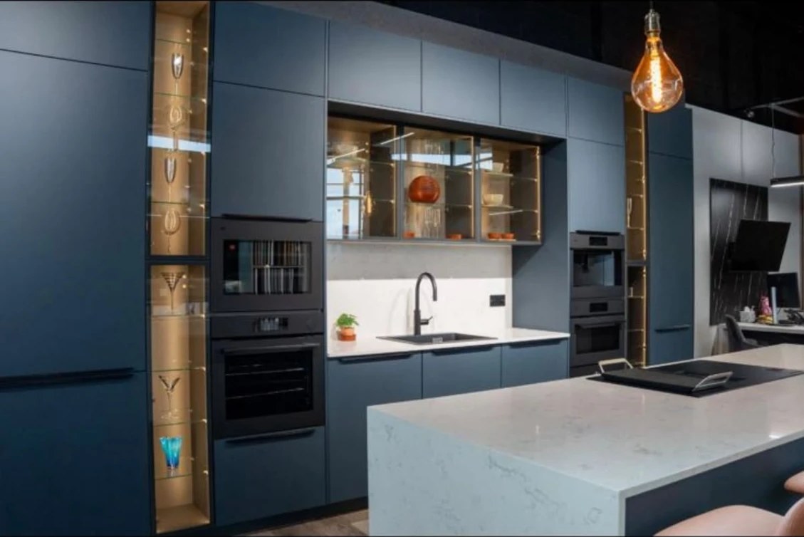 Deep blue matt German kitchen with illuminated glass display cabinets at the Kutchenhaus Irthlingborough showroom