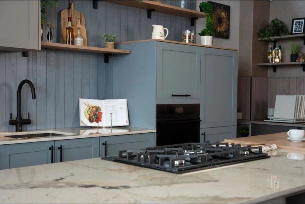 Marble-effect island with a gas hob and light blue shaker units
